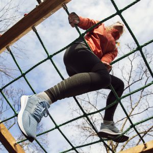 Low angle view of young woman on jungle gym