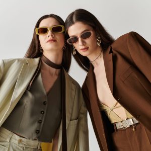 Beautiful twin sisters wear trendy outfits and accessories, exuding confidence and style.